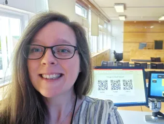 Colette O'Neill stood at the front of a bright and airy lecture theatre, smiling at the camera.