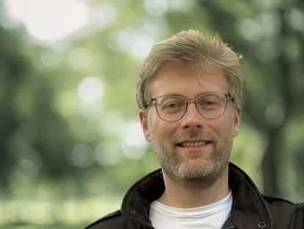 Matt Loxham looking directly at the camera with a blurry forest background.