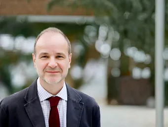 David Baldwin stood with an urban background with some greenery blurred.