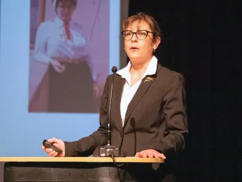 Roxana Carare giving a talk on a podium