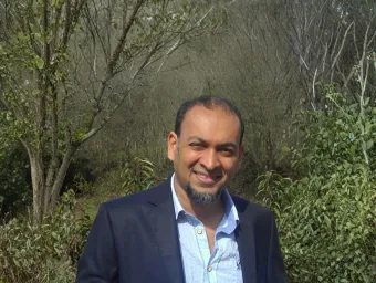 Arjuna Ratnayaka stood in front of greenery