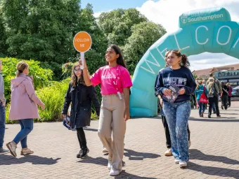 A student leading a campus tour at a university open day.