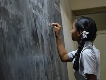 Girl writing on blackboard