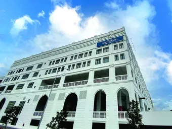A white stone building against a bright blue sky with white clouds, part of Southampton's Malaysia campus in Johor.