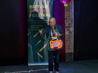 A British Science Festival performer wearing an apron model of the human digestive system.