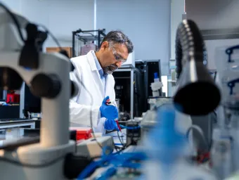 Professor Sumeet Mahajan uses a pipette while conducting research in a University laboratory.