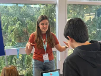 Researcher leading a hands-on workshop, explaining an activity to participants gathered around a table.