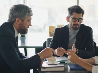people discussing grants with coffee