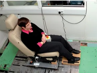 Participant seated on a horizontal vibration test rig used to study human response to whole-body vibration