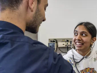 A student doctor practicing with a stethescope
