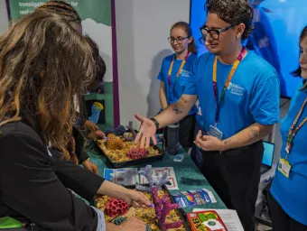 Visitors explore the Coral Detectives activity at the Future Chemistry Hub, examining coral models and learning about reef science with University of Southampton outreach staff.