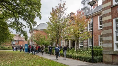 Students outside main building of Avenue Campus on spring day.