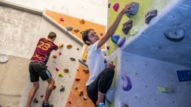 Students climbing indoor climbing wall. 