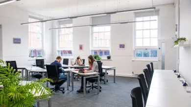 Students studying at desks in a bright, airy room.