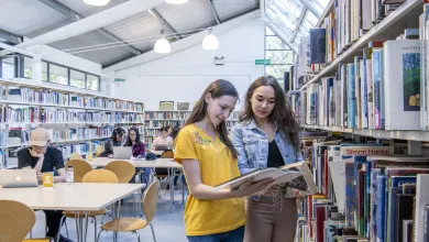 Students looking at books in university library