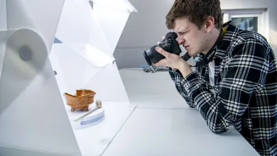 A student photographing small archaeological objects in a dedicated photography studio.