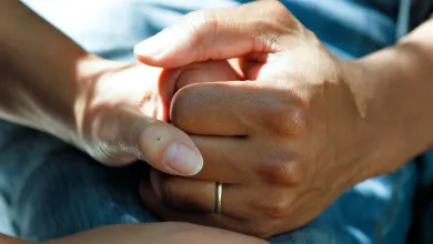 Comforting hands on a hospital bed