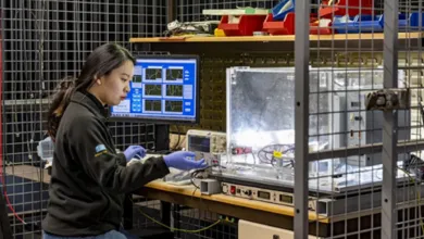 Researcher sitting at a work bench changing equipment settings