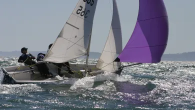 Two sailors in a small boat in rough waters