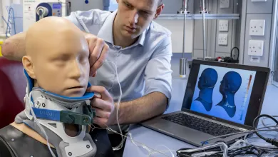 Researcher inserts sensors to measure pressure at the interface between a neck brace and a mannequin head model
