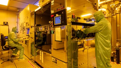 Researchers wearing cleanroom suits usin the deep ultraviolet (DUV) scanner facility