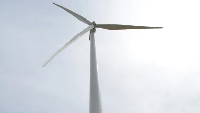 Wind turbine under cloudy sky.