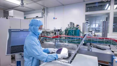 A researcher wearing a cleanroom suit
