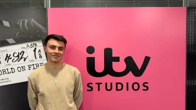 BA Spanish and Linguistics Graduate, Joe Dobinson standing by a sign for ITV studios.