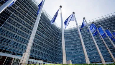 European parliament building with EU flags flying outside.