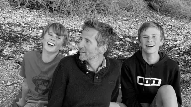A monochrome photo of Crispin Malpas and his sons in a casual moment, enjoying each others' company.