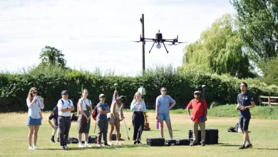 A group of people out on a field using an aerial drone.