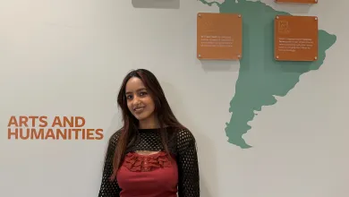 BA History student standing in front of a wall map of South America.