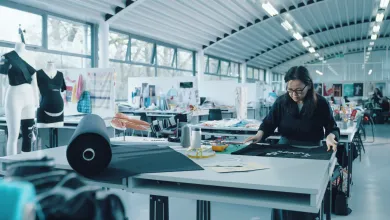 An e-textiles professor examining a smart textile garment with embedded electronics in a Winchester School of Art studio.