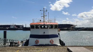 The waterfront harbor with a research vessel docked at National Oceanography Centre pier, captured from a straight-on, centered viewpoint.