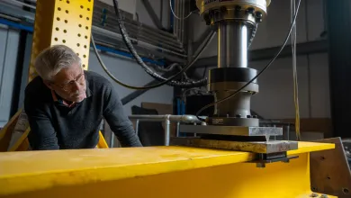 Professor David Richards inspecting a steel beam during laboratory testing.