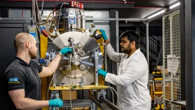 Two researchers working on a large experimental testing system in a laboratory
