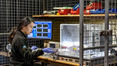 Researcher conducting electrical testing and monitoring data on laboratory equipment in a controlled test environment