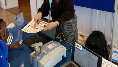 A member of staff at an outreach event showing children the Spectroscopy in a suitcase exhibit