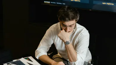 A person seated staring at their laptop