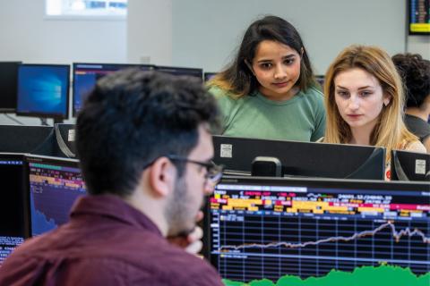Business analytics degree students looking at Bloomberg screens