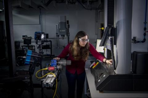 A student uses a piece of equipment in the testing and structures research lab