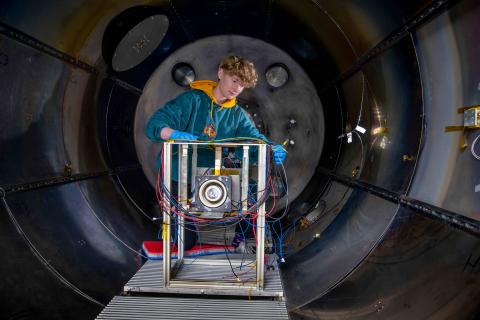 A student works on an experiment in the electric propulsion lab