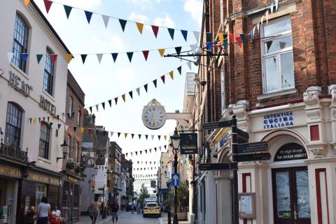 View of a typical UK town highstreet with shop fronts and bunting