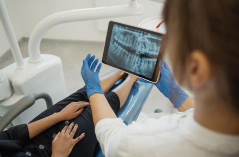 Dental professional and client in a consultation looking at an xray