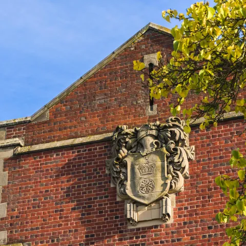 An old stone version of the University of Southampton coat of arms, affixed to the side of Hartley Library.