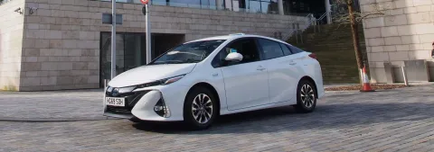 A white car parked outside of a university building