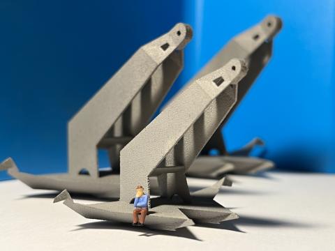 3D printed model of a man sitting on the edge of a huge metal structure