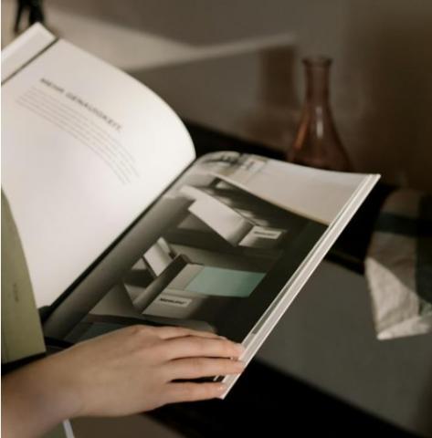 A person reading an office furniture catalogue
