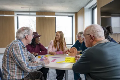 Kate discussing hearing loss and brain health with a group of older people 