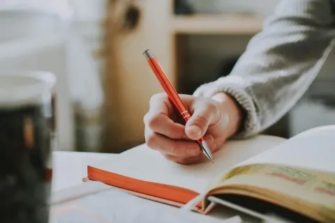 A hand writing in a book.